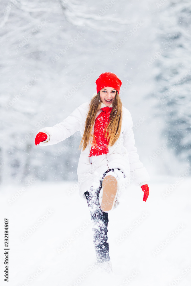 a girl in a winter jacket and warm accessories throw the snow and looking at the camera lens and smile a girl in a winter jacket and warm accessories throw the snow and looking at the camera lens and smile