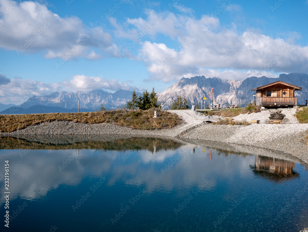 Image of mountain landscape with water reflection and little hut