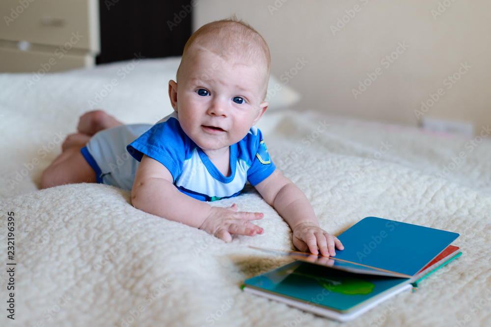 baby boy lying reading a children's book baby boy lying reading a children's book