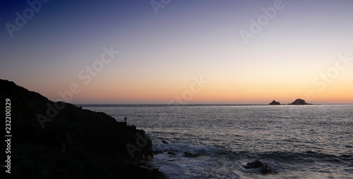 fisherman on rocks at sunset © Michael
