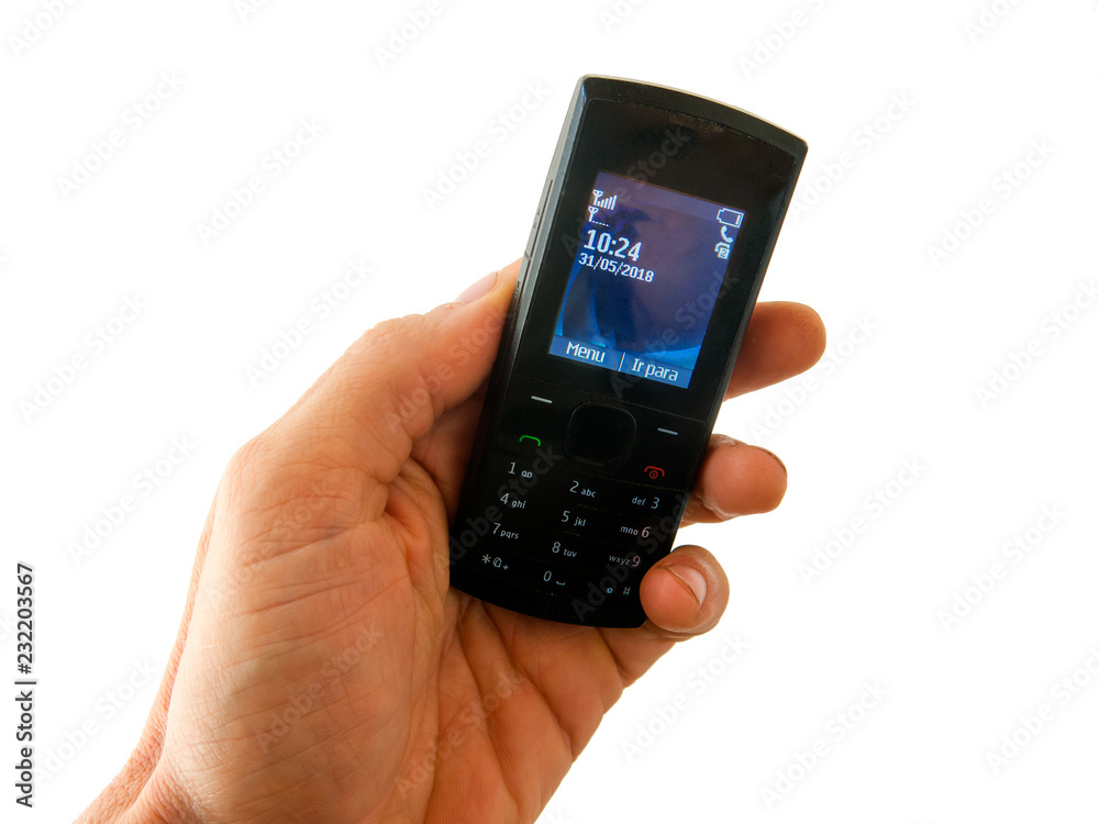 SAO PAULO, BRAZIL - MAY 31, 2018 - Hand holding an old style cel phone with white background - disconnected unplugged no smartphone SAO PAULO, BRAZIL - MAY 31, 2018 - Hand holding an old style cel phone with white background - disconnected unplugged no smartphone