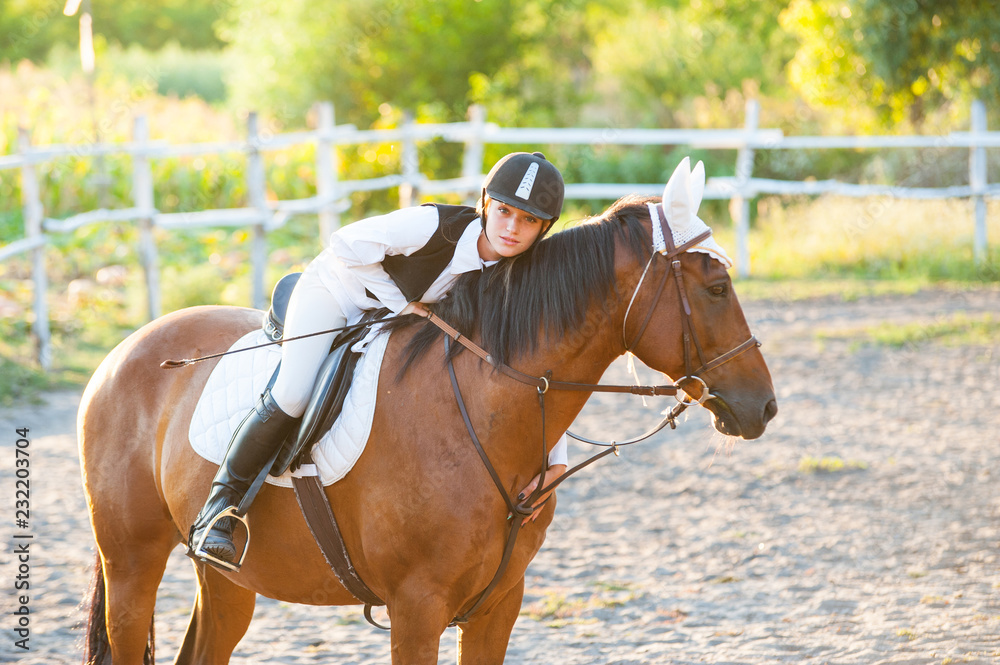 Girl equestrian rider riding a beautiful horse in the rays of the setting sun. Horse theme Girl equestrian rider riding a beautiful horse in the rays of the setting sun. Horse theme