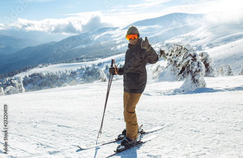 Nice man skiing in the mountains. Good skiing in the snowy mountains,  Winter is coming, first snowfall. Ski resort season is open. Ski equipment, trail. 