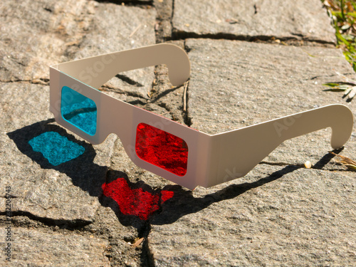 Red cyan stereophotography anaglyph 3D glasses on rocks ground pattern photo