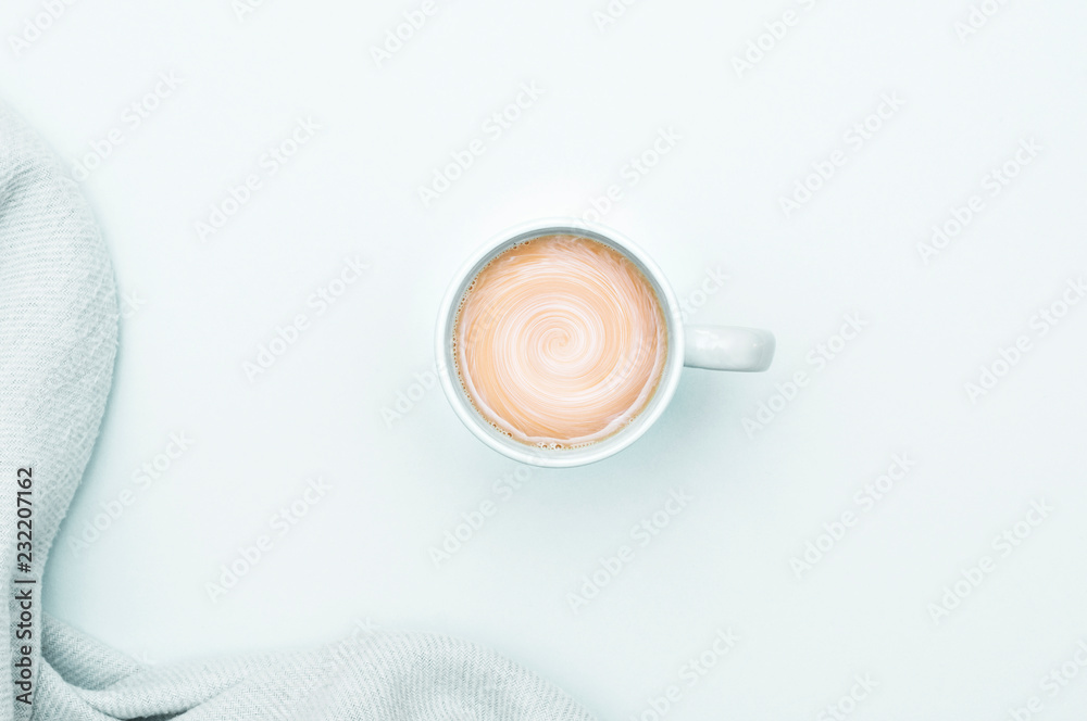 A cup of coffee with cream and a warm blanket. Cool background. A cup of coffee with cream and a warm blanket. Cool background.