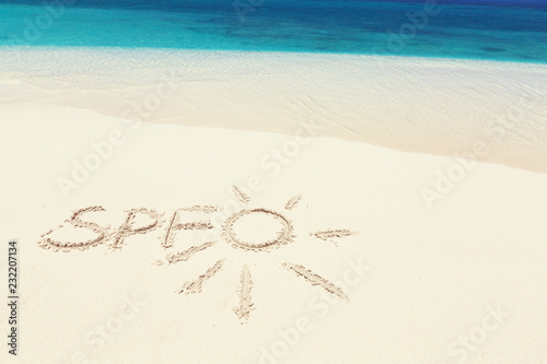 Fototapeta Naklejka Na Ścianę i Meble -  Written word SPF and drawing sun an sandy beach