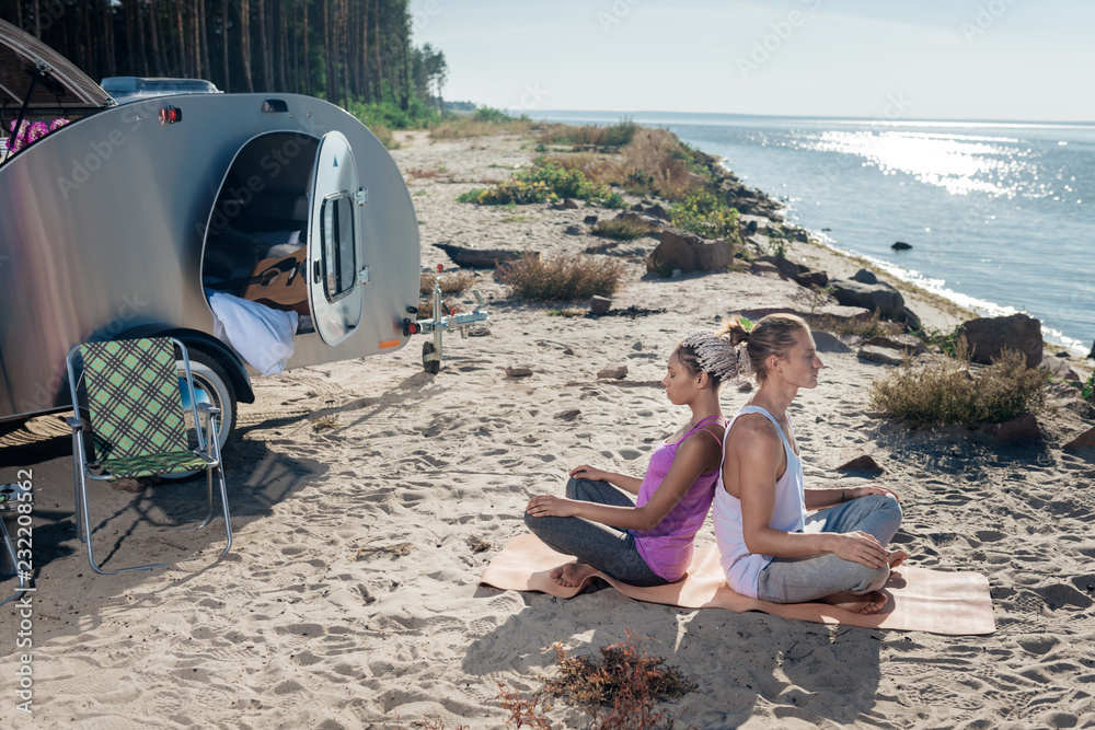 Support in yoga. Loving healthy couple living in eco trailer feeling protected while supporting each other in yoga Support in yoga. Loving healthy couple living in eco trailer feeling protected while supporting each other in yoga