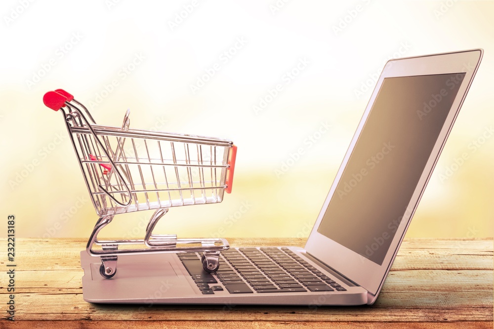 Online shopping concept with laptop and shopping cart