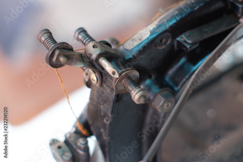Close-up part of an old sewing machine and detail on adjust thread tension regulater