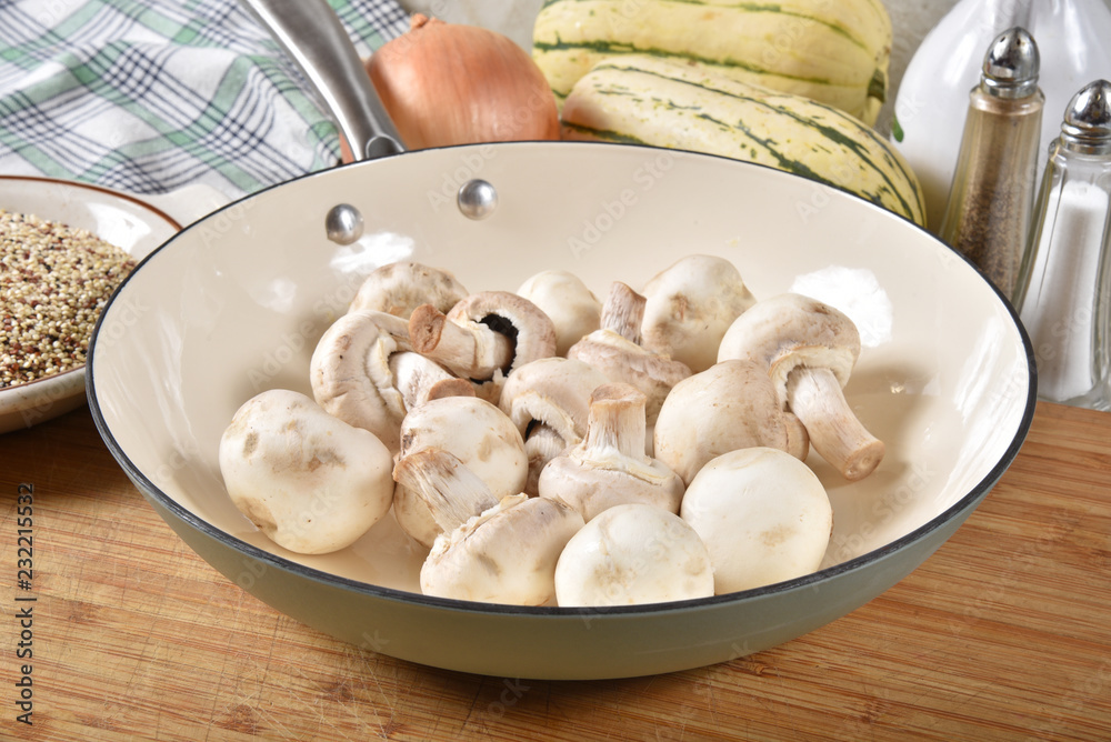 Raw button mushrooms in a cast iron skillet Raw button mushrooms in a cast iron skillet