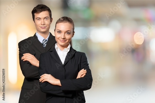 Two confident business people with crossed hands on background photo