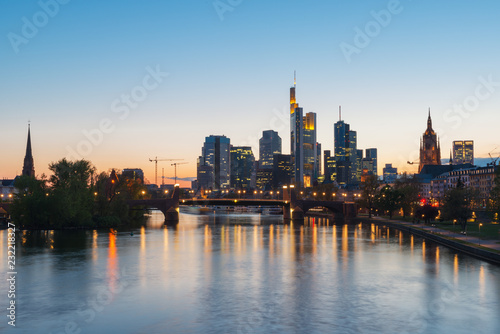 View of Frankfurt am Main skyline at dusk along Main river with cruise ship in Frankfurt, Germany