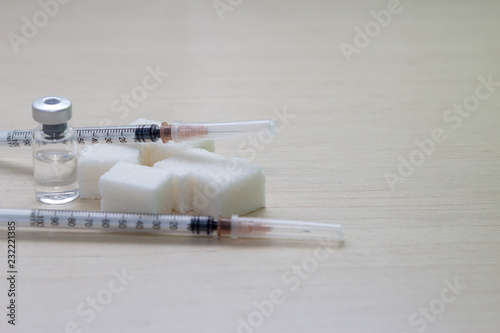 Treatment of diabetes. Syringe, ampoule and sugar photo