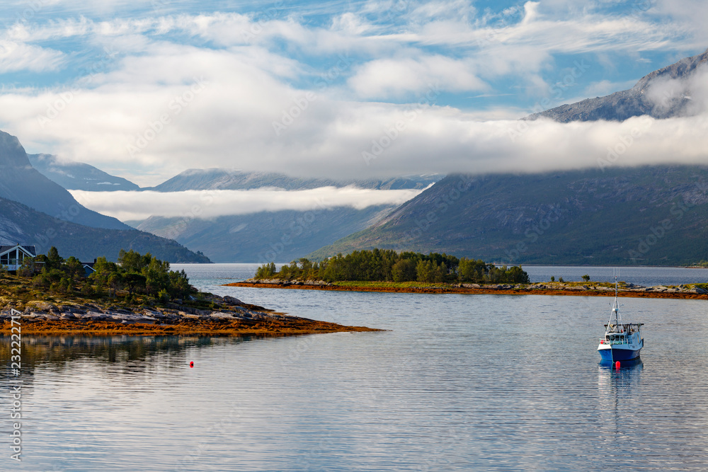 A fishing boat in a cloudy Norwegian Fjord