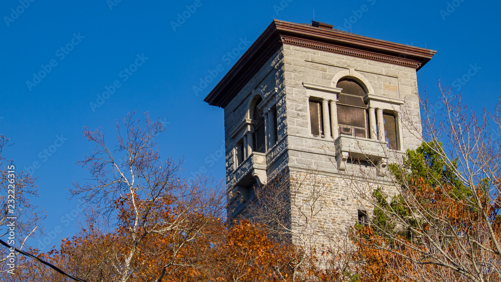 old stone tower in autumn park, no people, sunshine, peaceful