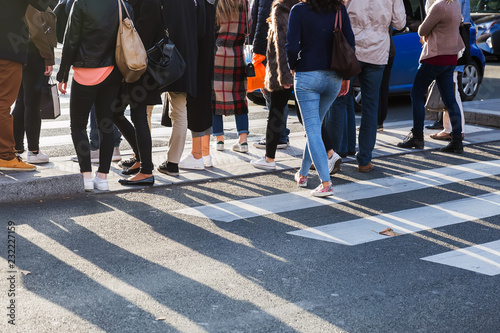 crowd of people crossing a street at the pedestrian crossing