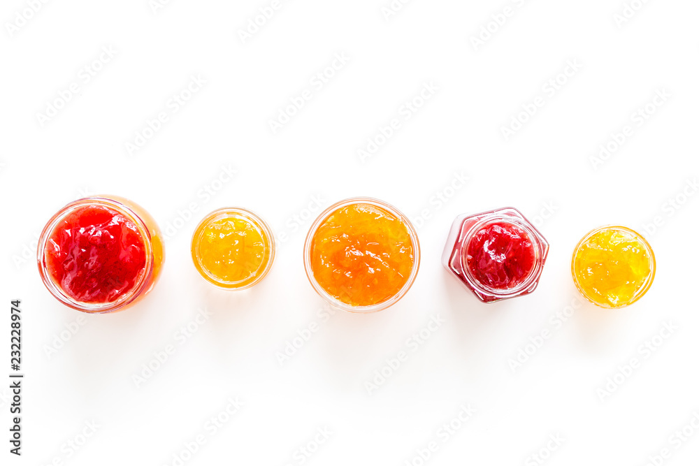Set of sweet jams in glass jars on white background top view copy space Set of sweet jams in glass jars on white background top view copy space