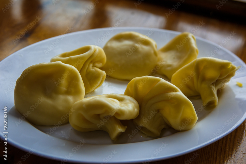 The national dish of Georgian cuisine is khinkali. A small child's hand touches food