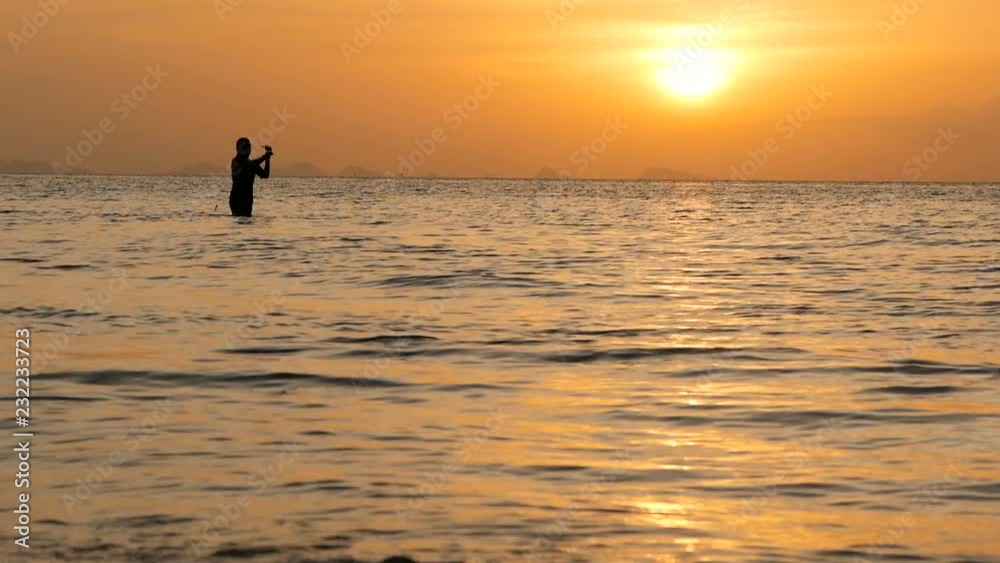 Fisherman silhouette in action when spinning on sunset time. Traditional Asian occupation and way of obtaining food. Fisherman silhouette in action when spinning on sunset time. Traditional Asian occupation and way of obtaining food.