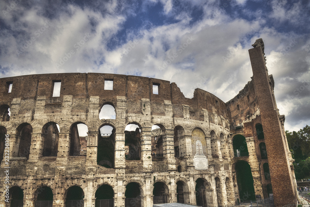 Mad clouds and Colisseum old building in Rome city, Italy