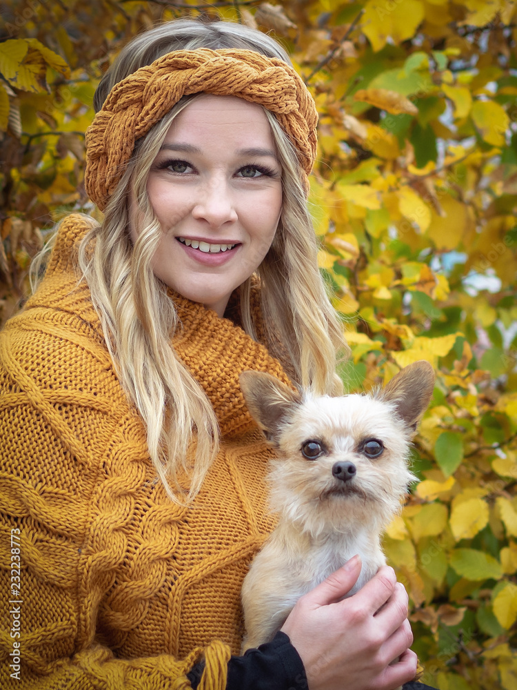 Portrait blonde frau mit locken mit hund im herbst vor strauch mit stirnband  und poncho Stock Photo | Adobe Stock