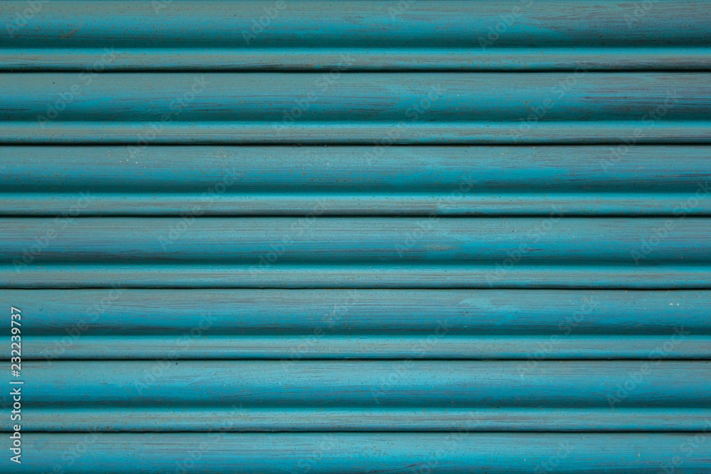 blue metal jalousie with horizontal lines. paint stains on the surface.