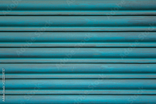 blue metal jalousie with horizontal lines. paint stains on the surface.