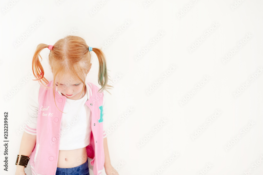 Red-haired girl in a pink sweatshirt on the white background Red-haired girl in a pink sweatshirt on the white background