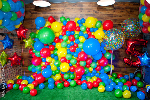 Photo zone for children's birthday decorated with bright multi-colored balloons.