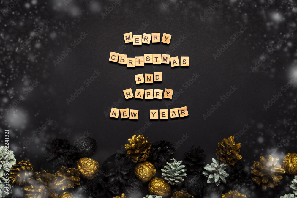 Pine cones and nuts painted in golden, black, white colors on a black background. Added text Happy New Year and Merry Christmas. Flat lay, top view