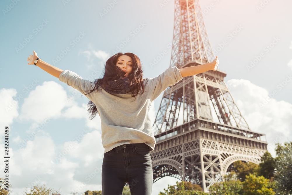 Fototapeta premium Młoda atrakcyjna szczęśliwa kobieta skacze z radości z wieży Eiffla w Paryżu, Francja. Portret podróży turystyczna dziewczyna na urlopowym chodzącym szczęśliwym outdoors. Gorgeous rasy mieszanej azjatyckich kobiet rasy kaukaskiej