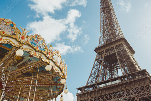 Eiffel tower and carousel againstblue sky, Eiffel Tower is one of the most iconic landmarks of France, and Paris is city of love. © Buyanskyy Production