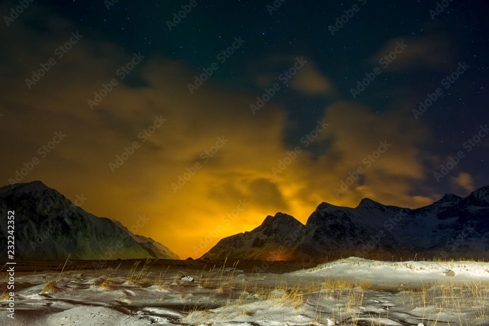 Snow-Covered Grass and Glow beyond the Mountains