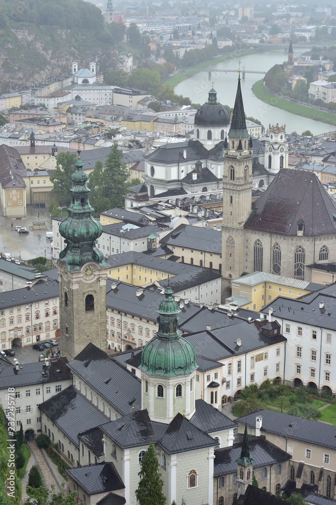 Vertical view of city of Salzburg on banks of river Salzach from Salzburg Fortress on rainy day.
