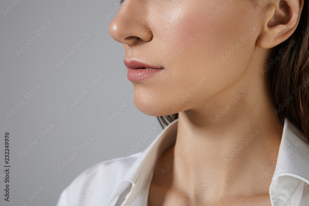 People, femininity, beauty, style and fashion concept. Cropped picture of unknown woman with shiny skin and pink lips posing against blank copyspace wall, dressed in white silk formal shirt People, femininity, beauty, style and fashion concept. Cropped picture of unknown woman with shiny skin and pink lips posing against blank copyspace wall, dressed in white silk formal shirt