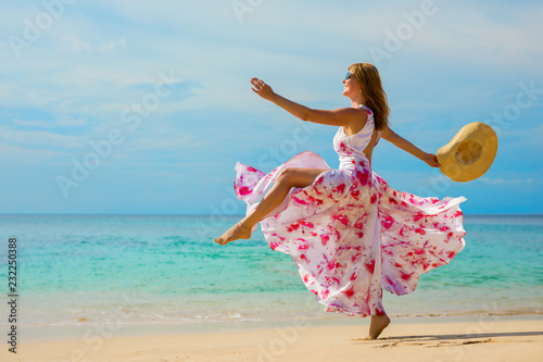 Happy woman making a big step forward on the beach
