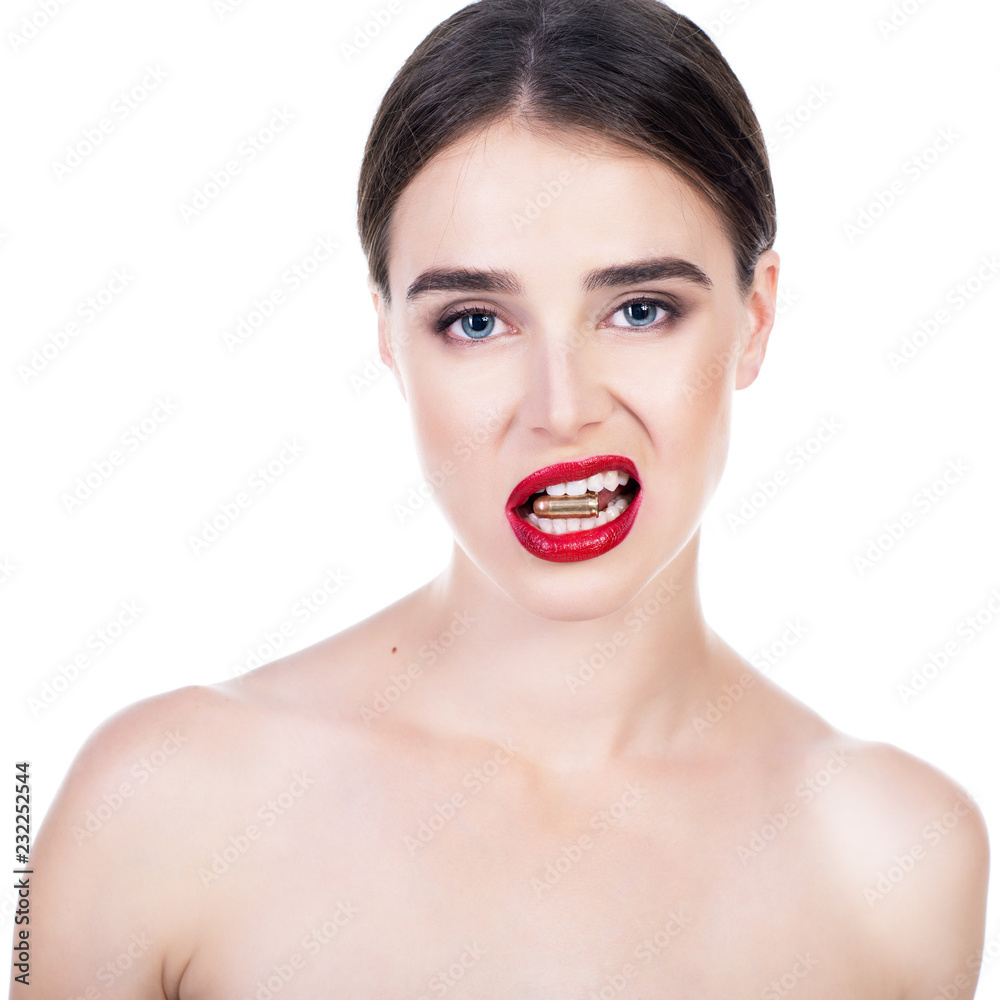 Beautiful young woman with shell in her mouth. Blue-eyed girl with red lipstick holding bullet in her teeth. Beauty will save the World, danger, war concept. Beautiful young woman with shell in her mouth. Blue-eyed girl with red lipstick holding bullet in her teeth. Beauty will save the World, danger, war concept.