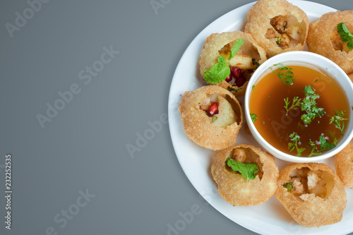 Delicious favorite north and south indian street food pani puri gol gappa with tamarind water served in white plate with mashed potato and chickpeas photo