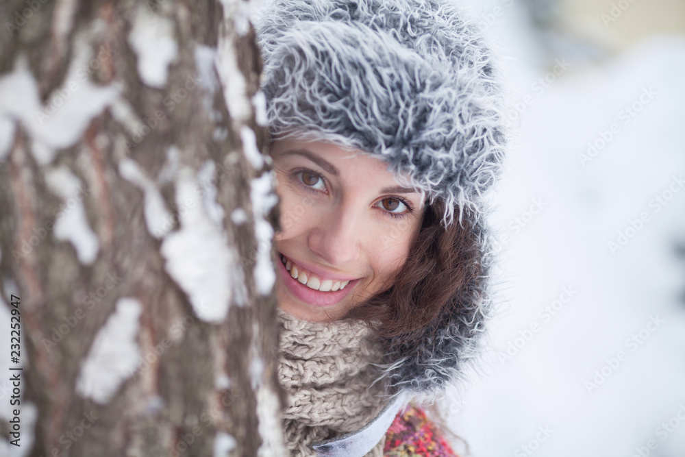 Portrait of a beautiful woman dressed a coat and fur hat in the winter field Portrait of a beautiful woman dressed a coat and fur hat in the winter field