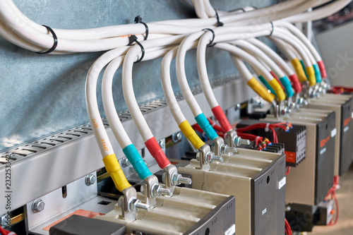 A large bundle of electrical cables or wires connected to contactors. High-power magnetic starters. Connection using a bolted connection. Large electrical Cabinet. Modern and reliable equipment.
