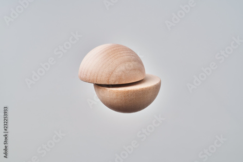 Abstract floating wooden half ball on white background