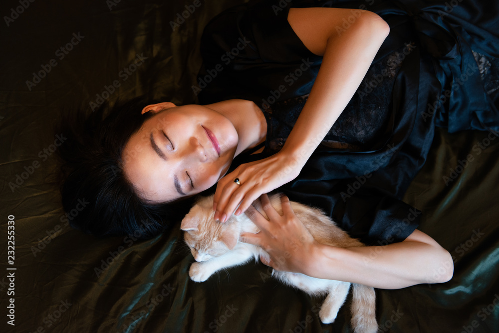 Beautiful chinese young woman wearing pajamas sleeps in bed with her ...