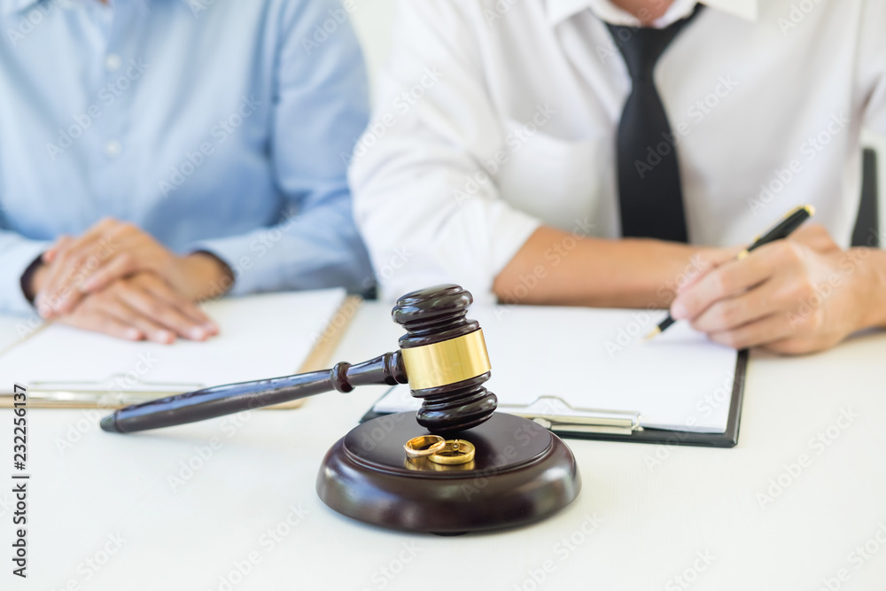 Angry couple arguing telling their problems to Judge gavel deciding on marriage to conclude an agreement on the divorce. They quarrel and argue with each other Angry couple arguing telling their problems to Judge gavel deciding on marriage to conclude an agreement on the divorce. They quarrel and argue with each other