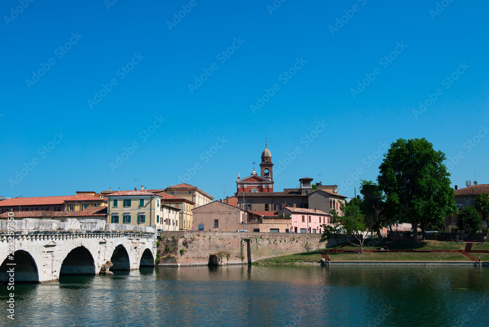 Picturesque view on channel with ancient bridge and old city center, Rimini, Italy, Europe.