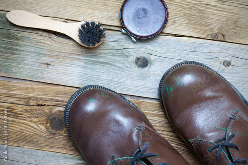 Still life with brown boots, shoe polish and shoe brush photo