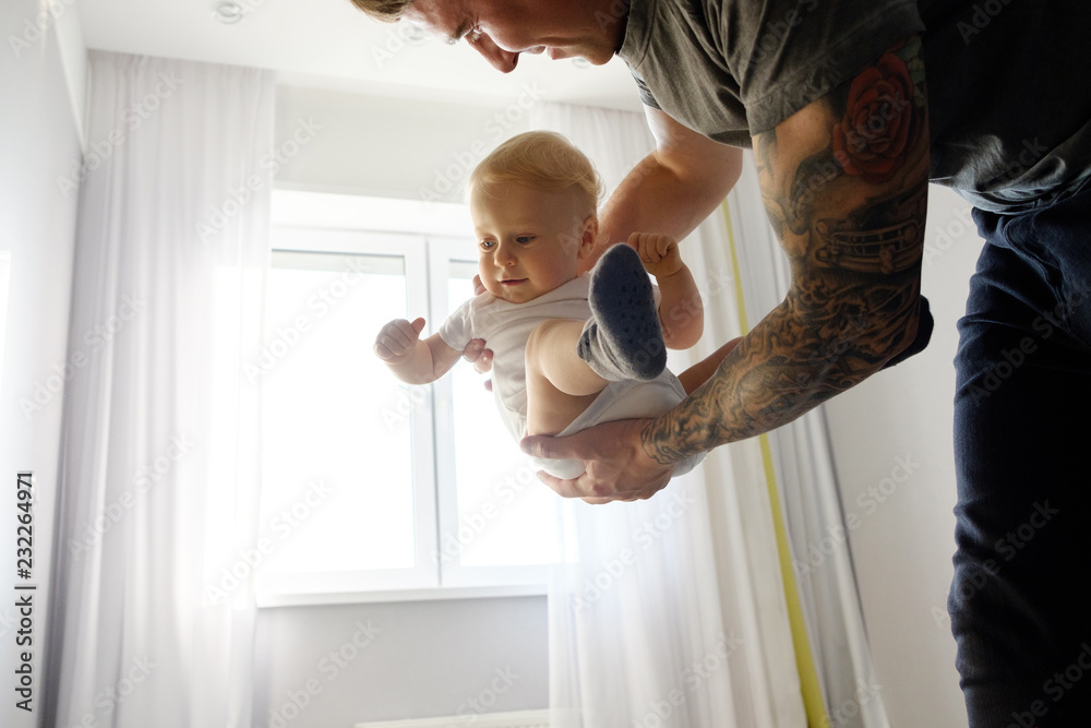 Fototapeta premium Father plays with the child at home. A happy family. Bright hues. Father's day holiday