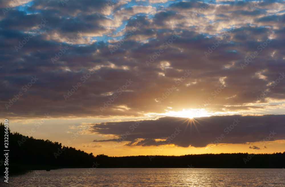 Sunset over a pond. Reflection of sunlight in the water. Red sky in the sunset light. Sunset over a pond. Reflection of sunlight in the water. Red sky in the sunset light.