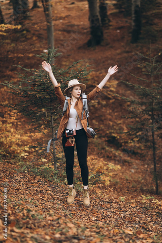 Girl with raised hands relaxing on top of the mountain  looking at beautiful autumn landscape