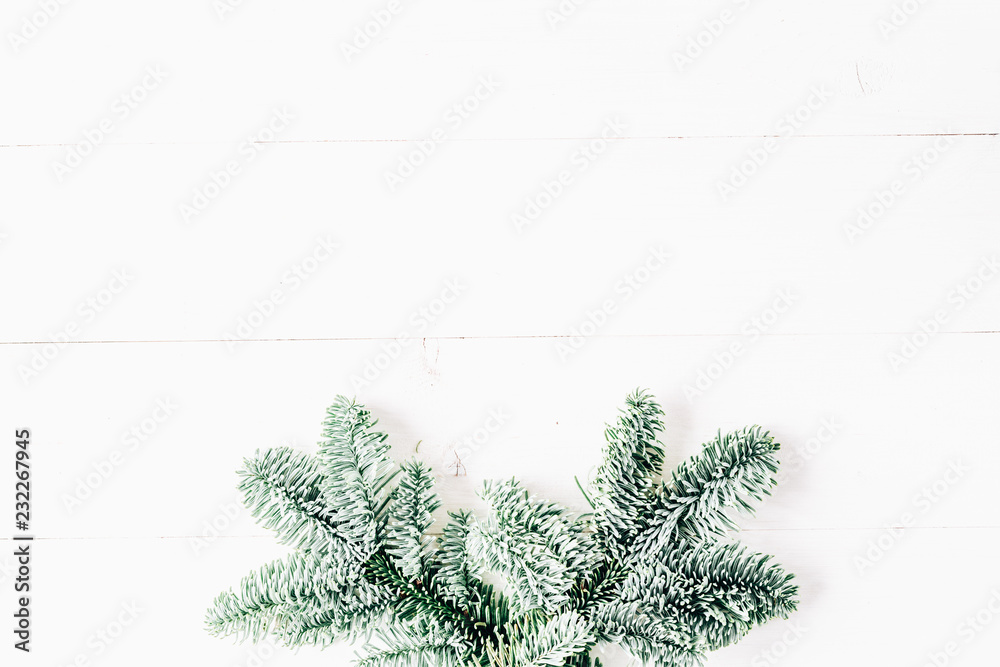 Christmas clean minimal modern composition. Christmas background, fir branches on wooden white background. Flat lay, top view, copy space