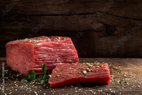 Raw beef meat with herbs on wood